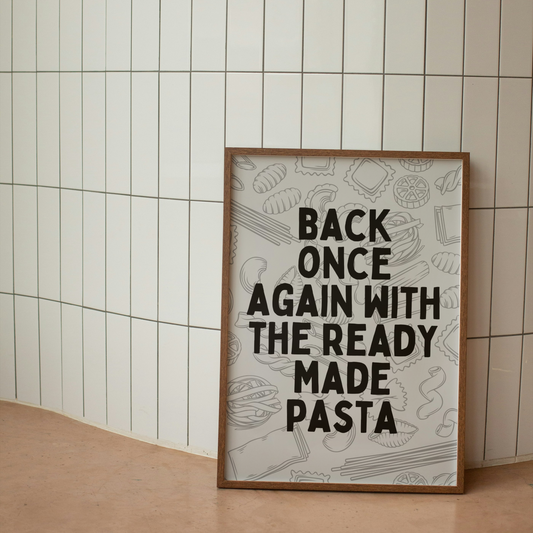 Framed poster with text 'Back once again with the ready made pasta' against a tiled wall.