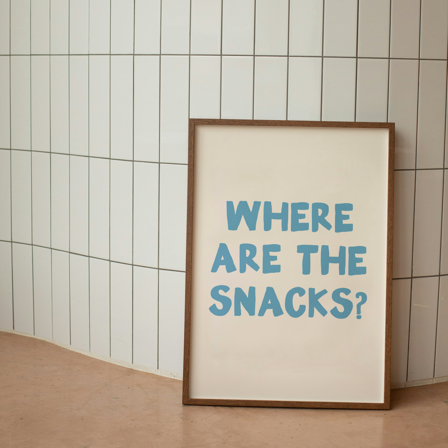Framed poster with 'WHERE ARE THE SNACKS?' text on a tiled wall.