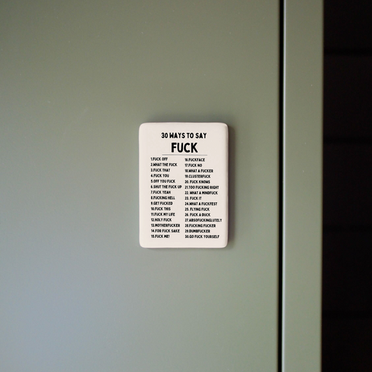 Small rectangular sign with text on a light gray wall.