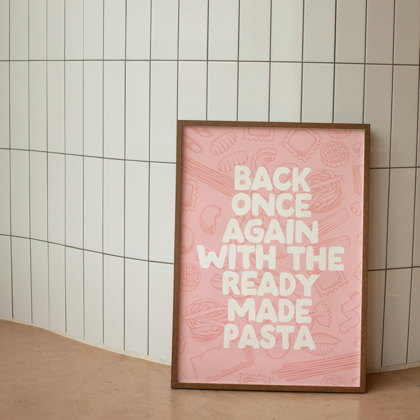 Framed pink poster with text against a tiled wall