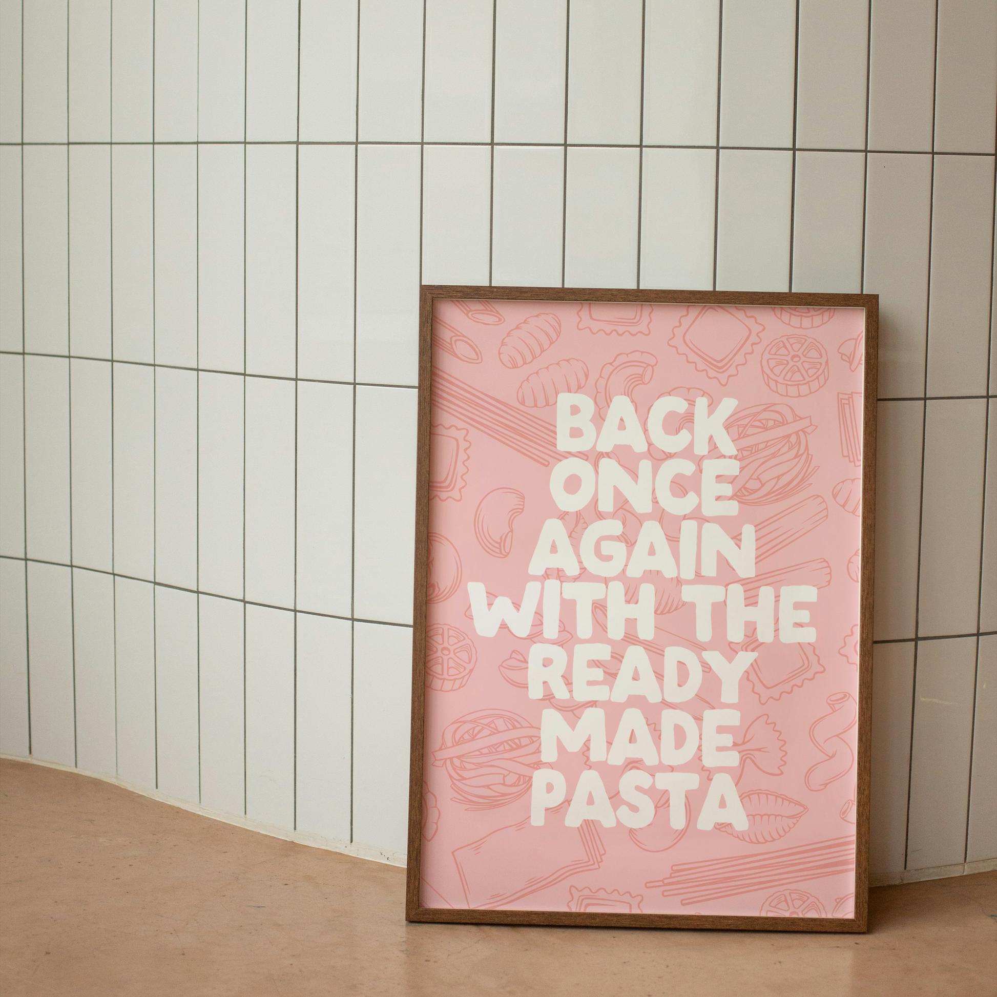 Framed pink poster with text against a tiled wall