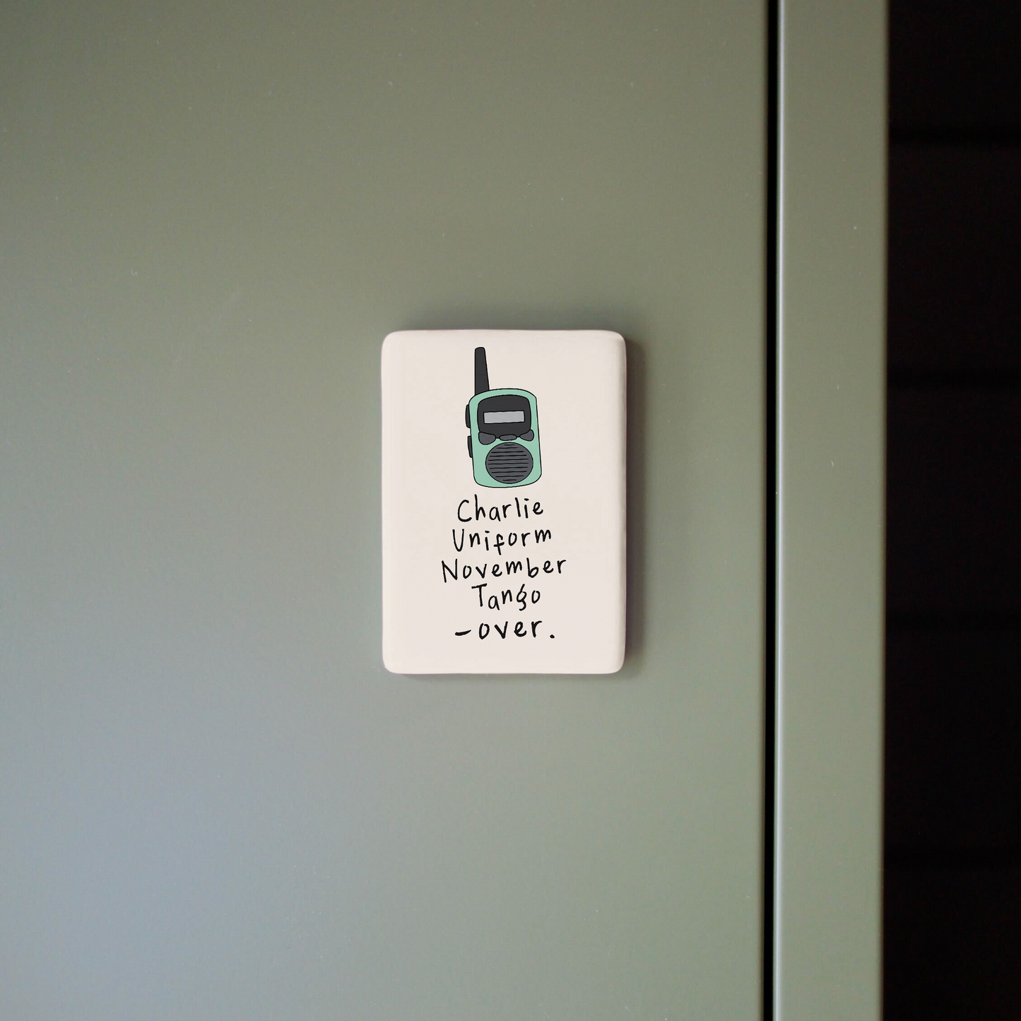 Small sign with a radio icon and text on a gray wall