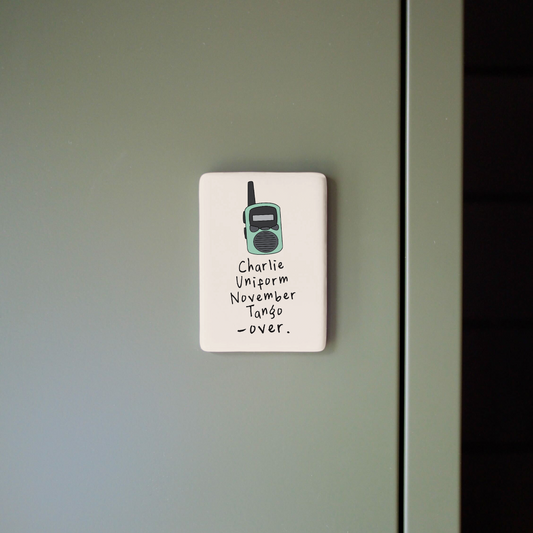 Small sign with a radio icon and text on a gray wall