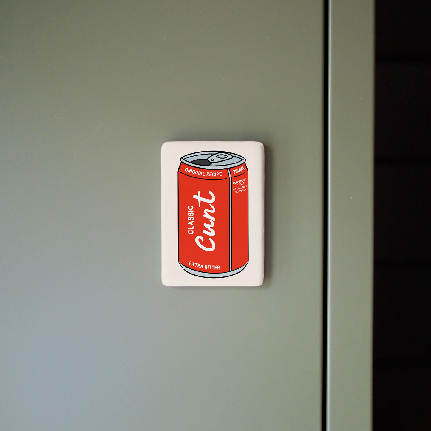 Fridge magnet with a red can design on a gray surface
