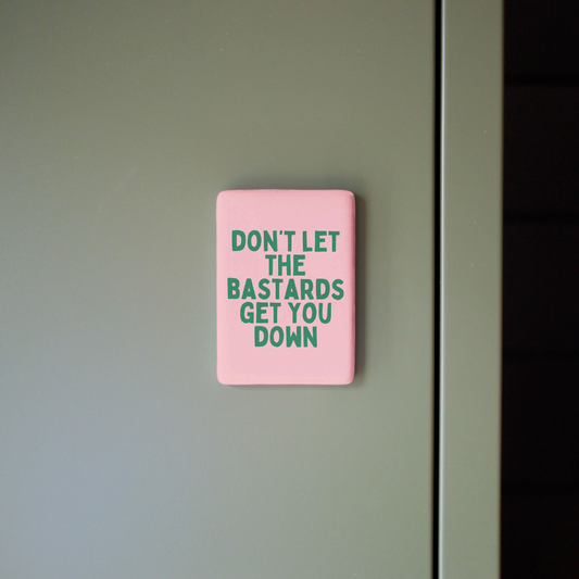 Pink sign with motivational quote on a gray wall