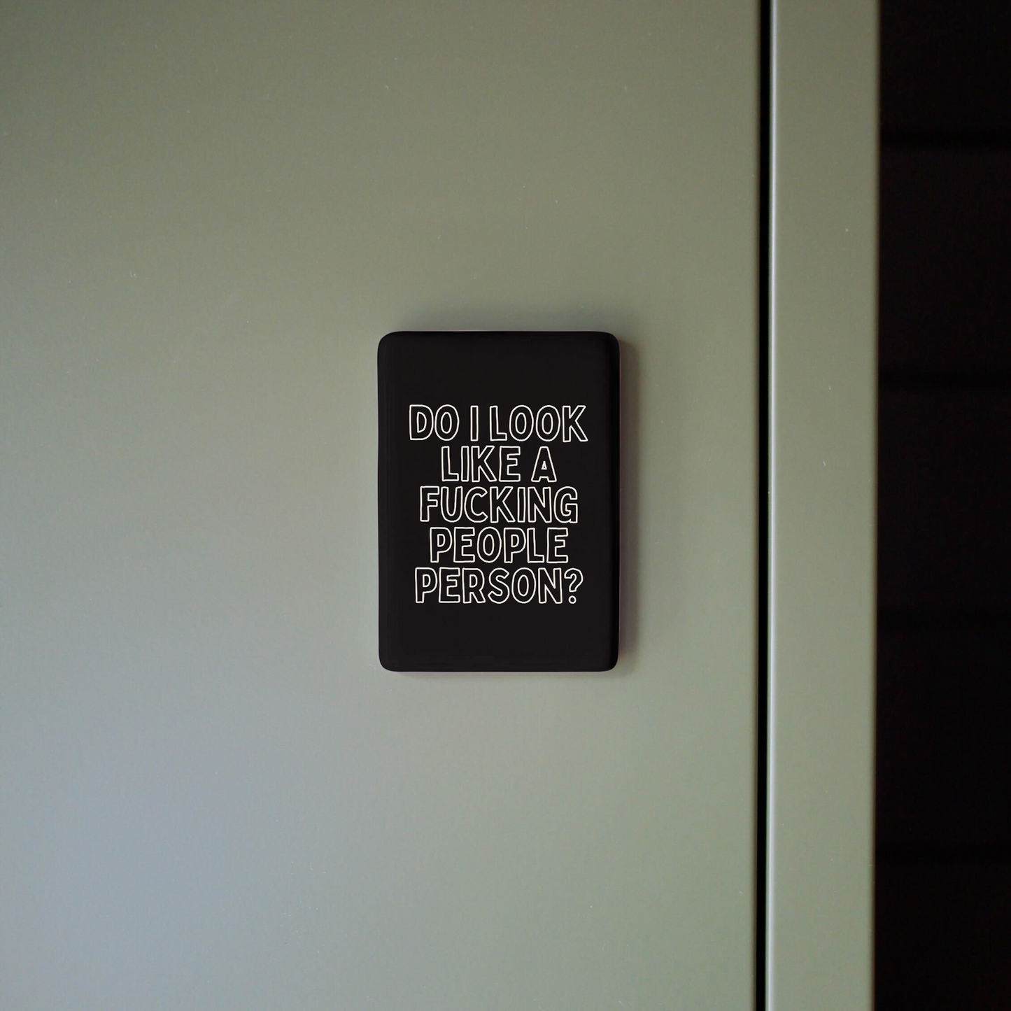 Black sign with white text on a white wall