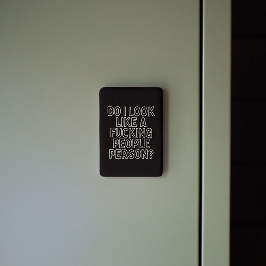 Black sign with white text on a white wall