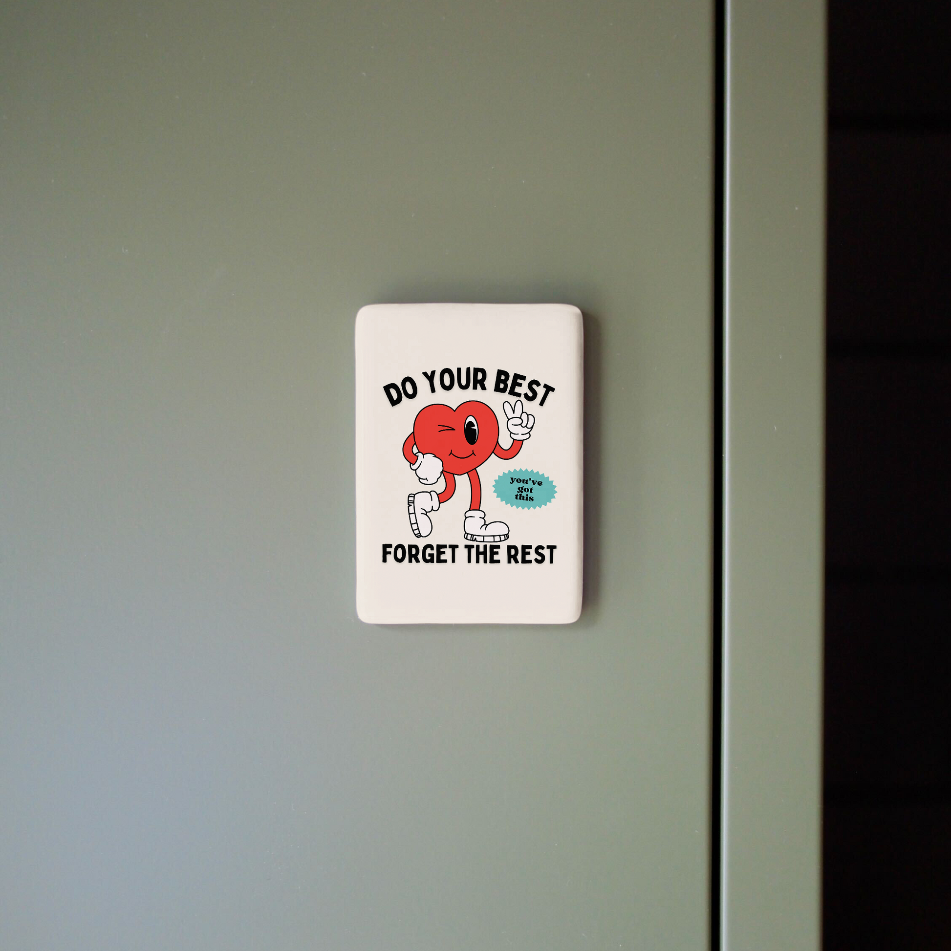 Motivational sticker with cartoon character and text on a light gray wall.