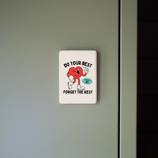 Motivational sticker with cartoon character and text on a light gray wall.