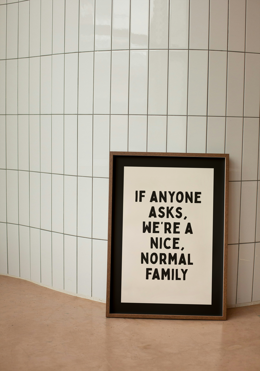 Framed poster with text 'If anyone asks, we're a nice, normal family' on a tiled wall.