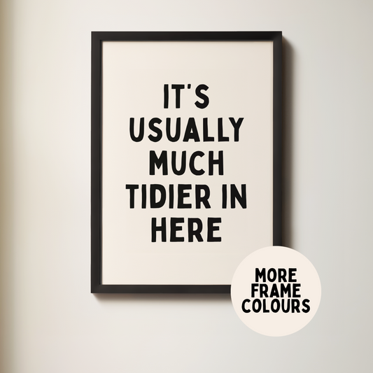 Framed poster with text 'It's usually much tidier in here' on a plain wall.