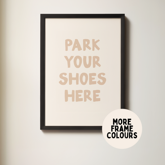 Framed poster with 'Park Your Shoes Here' text on a plain wall.