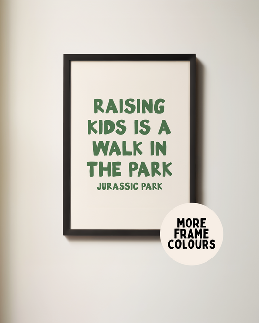 Framed print with text 'Raising kids is a walk in the park' on a plain wall.