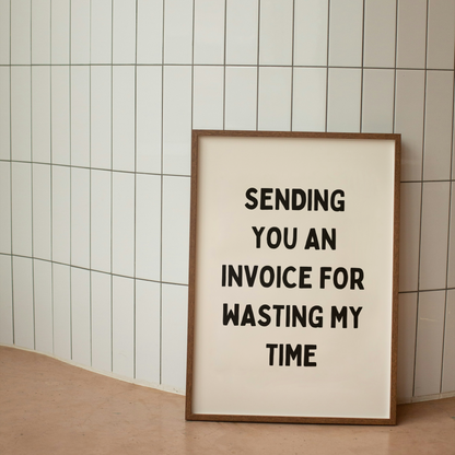 Framed poster with text 'Sending you an invoice for wasting my time' against a tiled wall.
