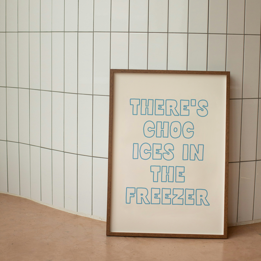 Framed artwork with text 'THERE'S CHOC ICES IN THE FREEZER' on a tiled wall.