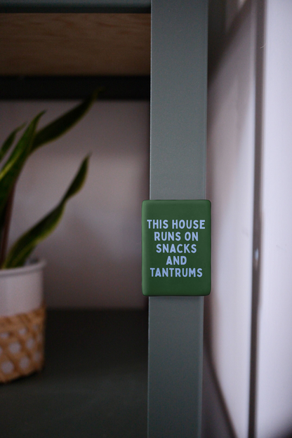 This House Runs On Snacks And Tantrums | Ceramic Magnet