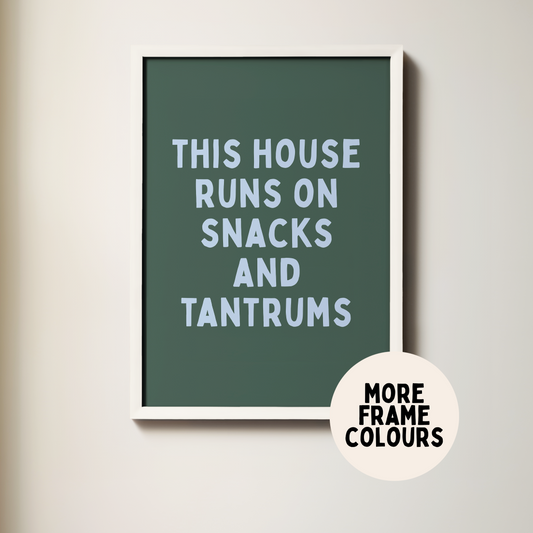 Framed poster with text 'This house runs on snacks and tantrums' on a light background