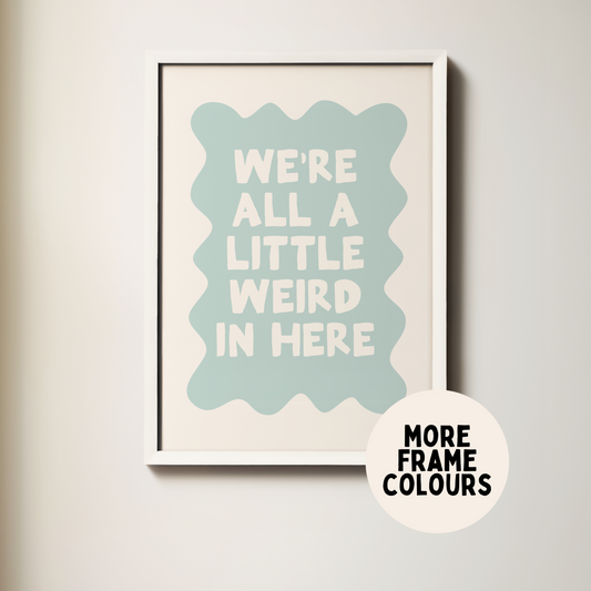 Framed poster with text 'We're all a little weird in here' on a light background
