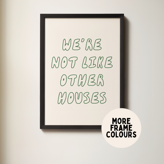 Framed poster with text 'We're not like other houses' on a plain wall.