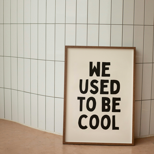 Framed poster with 'WE USED TO BE COOL' text on a tiled wall.